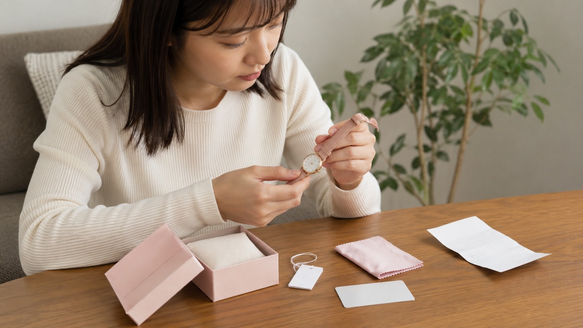 購入したファッション腕時計と保証書や付属品を確認する日本人女性